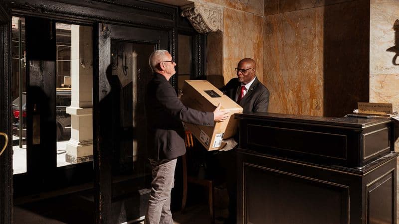 Image of a Security USA®'s concierge assisting a resident with packages.